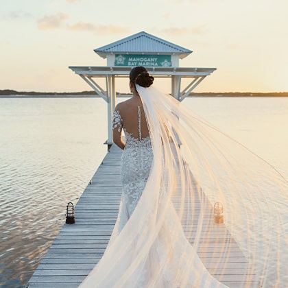 Bride running down marina dock at Mahogany Bay Resort & Beach Club